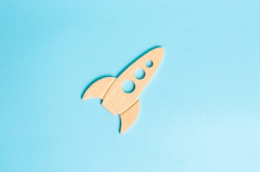 Mavi bir arka plan üzerinde ahşap bir roket. Retro tarzı. Uzay uçuşları ve başarıları yüksek teknolojileri kavramı. İş çıkar ve büyümek. Uzay turizmi. uydular başlatılması