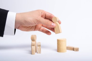 Elini bir işadamı iş takım elbiseli bir adam ahşap bir rakam elinde tutuyor ve başka bir şekil görevinden taşır. Bir çalışan personel yerine ateş kavramı