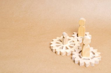 İnsanlar üzerinde ahşap vites stand. Teknoloji ve sanayi, düşünme süreci kavramı. Büyük bir karmaşık mekanizmasının bir parçası. İş süreci, kurum çalışma. İş takım, takım çalışması.