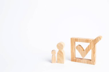 İki ahşap insan figürleri birlikte bir onay kutusunun yanındaki bekletin. Seçimler ve sosyal teknolojileri kavramı. Gönüllüler, partiler, adaylar, seçim electorates. İnsan hakları