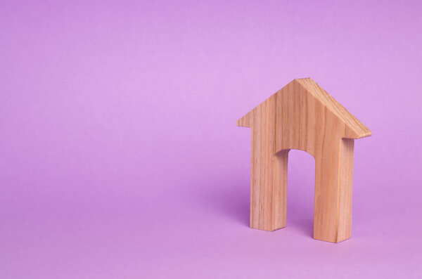 Figurine of a wooden house with a large doorway. Concept of real estate, purchase and sale of housing. Affordable housing at a low price. House for the family