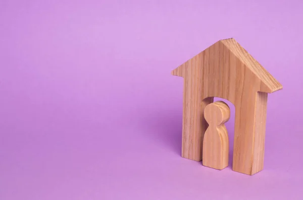紫色の背景に家の男の木製の置物 集合住宅 不動産のコンセプトです 売買アパート 若い家族のための住宅手頃な価格すること 権利の保護 — ストック写真
