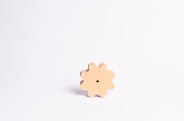 Wooden gear on a white background. Abstract background for presentations and banners. The concept of technology and industry, the think process. Part of a large complex mechanism