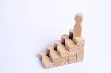 Ahşap bir adam bir sosyal veya kariyer merdiven başında duruyor. İş başarı kavramı. İnsanlar merdivenlerden. Diğer işçiler kullanın. Bir adam ahşap bir rakam merdiven için başarı yükselir..