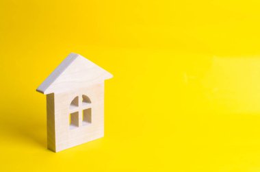 Sarı bir arka plan üzerinde ahşap ev. Alış ve satış konut, bir ev inşa kavramı. Kiralık Daire. Emlakçılar. Gayrimenkul, özel mülkiyet, onarım ve yenileme.