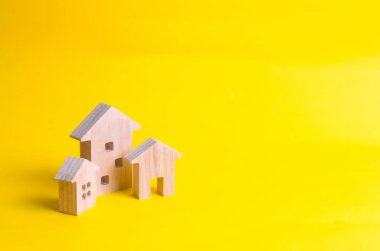 Üç ev sarı bir arka plan üzerinde. Alış ve satış Emlak, inşaat. Daire ve daire. Şehir, yerleşim. Minimalizm. sunumlar için. Emlak Piyasası.