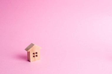 Küçük bir ahşap ev pembe bir arka plan üzerinde duruyor. Alış ve satış Emlak, kavramı kiralama. Bir ev için arama. Uygun fiyatlı konut, kredi ve kredi. İş yatırımları
