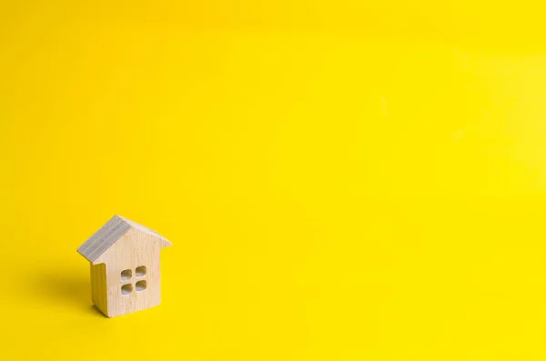 小さな木の家は 黄色の背景に立っています 不動産を売買することの概念を借りるします 家を探す現実的なハウジング 信用および貸付け金 事業への投資 — ストック写真