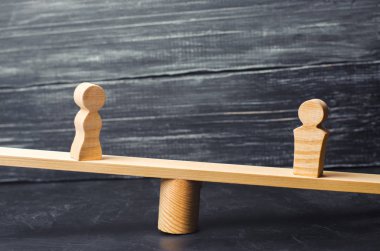 Bir erkek ve bir kadın ölçekler üzerinde rakamlar. eşitsizlik kavramı: erkek ve kadın bir tartı üzerinde denge, cinsiyet ücret farkı. boşanma. Mahkeme özelliğinde bölümü. Aile içinde sosyal rolü