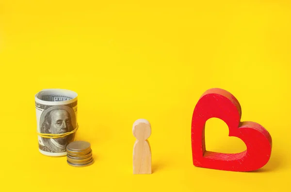 a wooden man chooses between money and love. Passion versus profit. Family or career choice. family psychology.