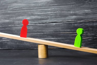 ahşap figürler insan. rakip iş ölçekler üzerinde durmak. deneme. çatışma. zafer ve yenilgi. kötü ve iyi çalışan. yeşil şekil kırmızı olanı daha ağır basar. başarı ve güç kavramı. rekabet