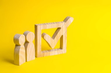 İnsan figürleri büyük bir onay kutusunun yanında duruyor. Seçmenlerin bir Başkan veya bir parti için oylamaya katılın. Eyalet seçimleri, referandum, nüfus anketi. İstatistiksel veri. Oy hakkı.