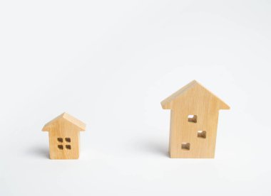 Beyaz bir arka plan üzerinde iki ahşap ev. Büyük bir ev daha iyi o zaman küçük bir. Bir özel ev ya da daire satın kavramı. Konut tipi seçimi. Yüksek katlı bir binada daire.