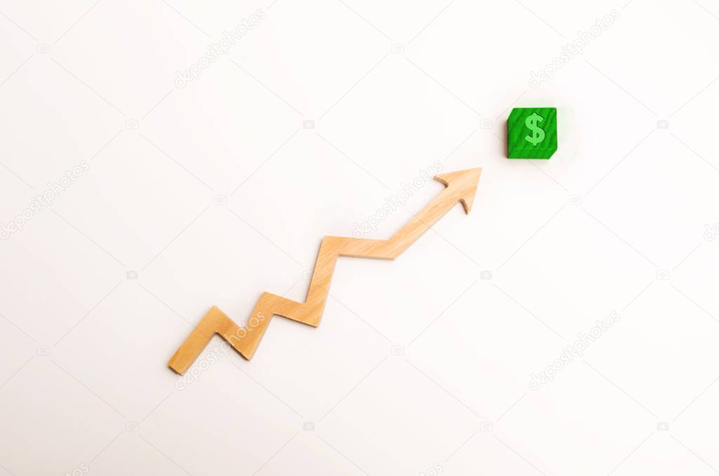 Wooden arrow up arrow points to a green block with a dollar symbol. The concept of revenue growth and cost, increase in profits. Increase the efficiency of business. Minimalism.