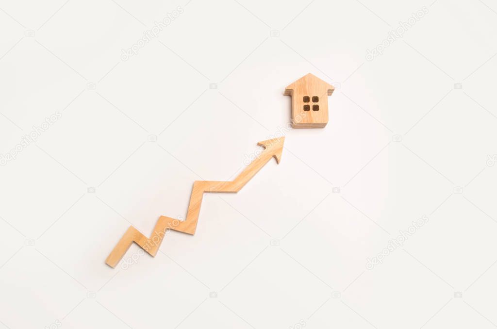 Wooden arrow up arrow points to a wooden house. The concept of revenue growth and cost. Increase the efficiency of business. Improving the quality of life and living conditions. Demand for real estate