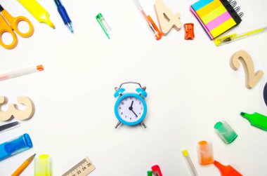 okula dönüş. Okul masa mavi çalar saat. ileti örneği. aksesuarlar. Beyaz arka plan. çıkartmalar, renkli kalem, kurşun kalem, makas. yukarıdan görüntüleyin. düz yatıyordu. kopya alanı
