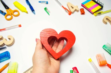 Ben okulu seviyorum! öğrenci kalp masanın arka plan üzerinde onun elinde tutar. öğrenme sevgisi. ileti örneği. okula dönüş. Eğitim. Genç ilk okulu seviyorum.