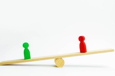ahşap figürler insan. rakip iş ölçekler üzerinde durmak. deneme. çatışma. zafer ve yenilgi. kötü ve iyi çalışan. Kırmızı figür yeşil olan daha ağır basar. başarı ve güç kavramı. rekabet