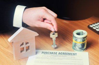 Sözleşme bir ev satın almak için. Emlakçı anahtarları tutar. ev modeli ve dolar. Gayrimenkul yatırım. satın alma, kiralama ve daire satıyor. Emlakçı