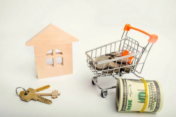 Property investment and house mortgage financial concept. buying, renting and selling apartments. real estate. keys, dollars, wooden house and Supermarket trolley. credit