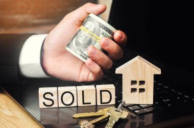 ev satışı online. Emlak kavramı. Ev, anahtarları, dolar ve yazıt model 