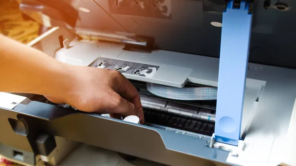 a man is repairing a printer. digital photocopier machine. printing equipment, 3d scanner