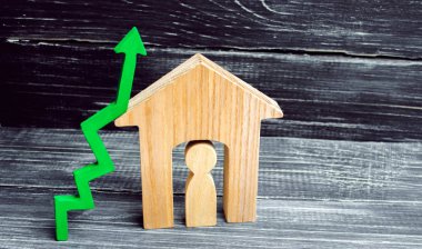 ahşap evin içinde bir adamla. yeşil ok yukarı. Emlak için yüksek talep kavramı. konut enerji verimliliğini artırmak. içinde ev fiyatları yükseldi. Özellik. nüfus artışı. metin için yer