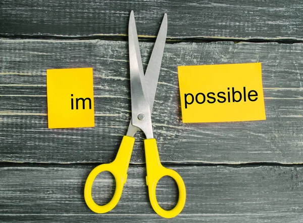 Impossible Is Possible Concept. card with the text impossible, scissors cut a word to them. success and challenge concept. I can, goal achievement, potential, overcoming