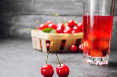 meyve suyu veya komposto kiraz ile. bir gri beton zemin, yaz berry, yaz içeceği sepet içinde taze Olgun kırmızı kiraz