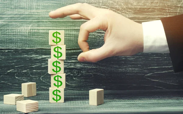 işadamı resmi dolar olan bir küp kaldırır. mali ve ekonomik kriz. sermaye çıkış. ekonominin sabotaj. iflas. küçük işletmeler üzerinde baskı. düşen fiyatlar. nakit kaybı