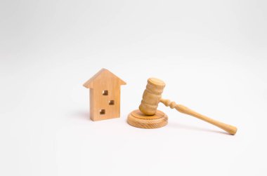 Wooden apartment house and hammer of the judge on a white background. The concept of the trial of an apartment building, the examination of cases between the tenants of the house. clipart