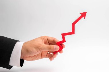 Bir işadamı el Beyaz bir arka plan üzerinde kırmızı bir ok tutar. Yetiştirme ve gelir ve karlar, yükselen fiyatlar ve maaşlarını çarparak kavramı. Yüksek talep, pozitif ekonomi.