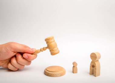 Yargıç bir çekiçle vurmak ve bir boşluk bir çocuk şeklinde bir kadın figürü üzerinde bir karara işlemek çalışır. ebeveyn haklarının yoksunluğu çocuk kabulü için yargı süreci.