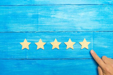 İşadamı'nın el takım elbiseli beşinci star puan. Beşinci yıldız almak. Oteller ve restoranlar ile ilgili değerlendirme, eleştirmenler ve ziyaretçi değerlendirilmesi kavramı. Kalite düzeyi, iyi hizmet.