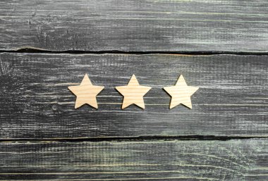 Karanlık bir arka plan üzerinde üç yıldız. Derecelendirme ve değerlendirme kavramı. Otel, Restoran, mobil uygulama derecesi. Kaliteli hizmet, alıcı seçim. İş başarı