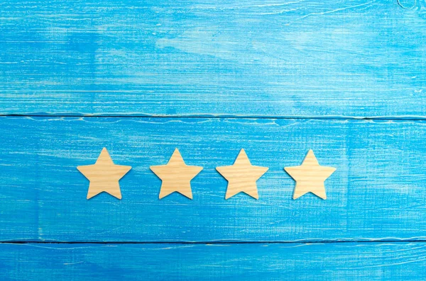 four stars on a blue background. The concept of rating and evaluation. The rating of the hotel, restaurant, mobile application. Quality service, buyer choice. Success in business