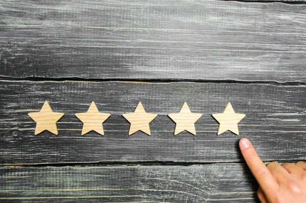 İşadamı'nın el takım elbiseli beşinci star puan. Beşinci yıldız almak. Oteller ve restoranlar ile ilgili değerlendirme, eleştirmenler ve ziyaretçi değerlendirilmesi kavramı. Kalite düzeyi, iyi hizmet.