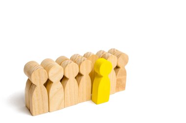 Seçilmiş kişi diğerleri arasında. Yeşil renk bir insan figürü kalabalıktan sıyrılıyor. Ahşap figürler insan. Yetenekli bir işçi, başarılı bir seçim. Promosyon. Bir çalışan için arama kavramı.