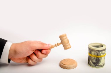 Ahşap yargıç çekiç ve dolar beyaz zemin üzerinde bir bohça bohça. Yargı alanında yolsuzluk kavramı. Banknot gözünü Franklin'in bir elastik bant ile kaplıdır.