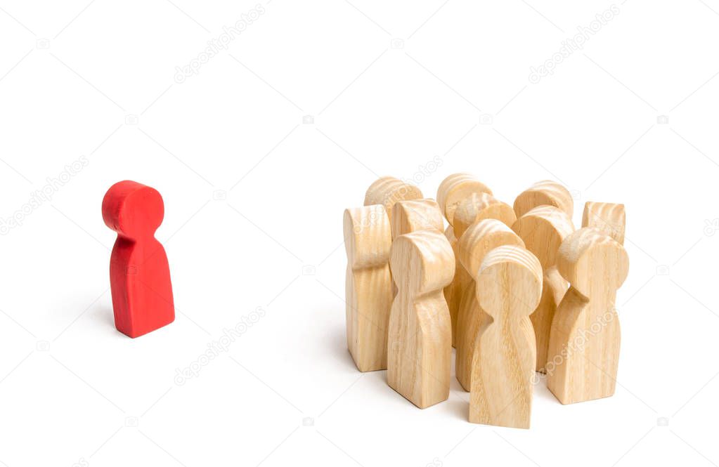 The crowd of wooden figures of people stand distantly and look at the red man. The rejected person tries to establish contact with the group. Bad business leader, expulsion from the team.