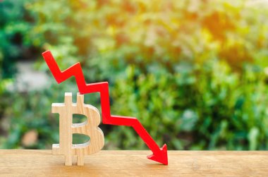 bitcoin maliyeti düşer. Kripto-döviz piyasasının çöküşü. Blockchain teknoloji. ahşap işareti bitcoin ve kırmızı ok aşağı.