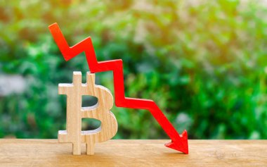 bitcoin maliyeti düşer. Kripto-döviz piyasasının çöküşü. Blockchain teknoloji. ahşap işareti bitcoin ve kırmızı ok aşağı.