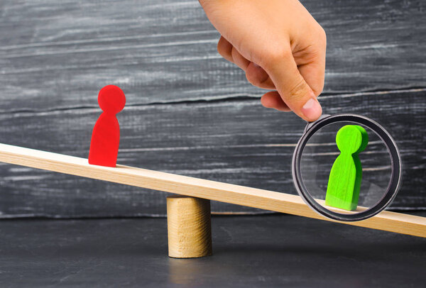 деревянные фигуры людей. соперники в бизнесе стоят на весах. Судебный. Конфликт. Победа и поражение. плохой и хороший работник. Зеленая фигура перевешивает красную. концепция успеха и власти. конкуренция
