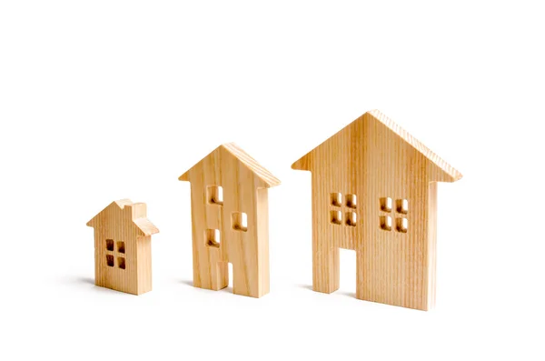 Wooden houses stand in ascending order on a white background. Isolate The concept of increasing population density and high-rise buildings. Agglomeration and urban growth. population growth.
