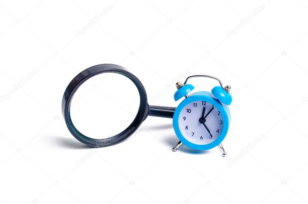Magnifying glass and a clock. The concept of finding free time for a hobby, family, leisure and work. Temporary replacement search. Urgent search, investigation. Planning and self-improvement