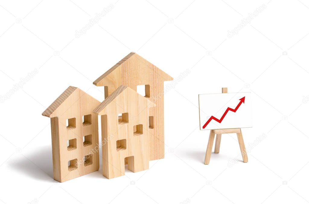 Wooden houses stand with red arrow up. Growing demand for housing and real estate. The growth of the city and its population. Investments. concept of rising prices for housing or rent.