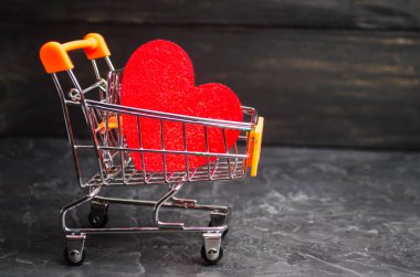 süpermarket arabası kırmızı kalbinde. aşk satın alma kavramı. Sevgililer günü. sarı arka plan. Alışveriş aşk. Favori mağaza. Sevgi ve mutluluk satın. Para için samimi hizmetleri