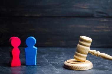 ahşap figürler bir erkek ve bir kadın hakimin tokmak duruyor. eşitsizlik kavramı: cinsiyet ücret farkı. boşanma. Mahkeme özelliğinde bölümü. Aile içinde sosyal rolü