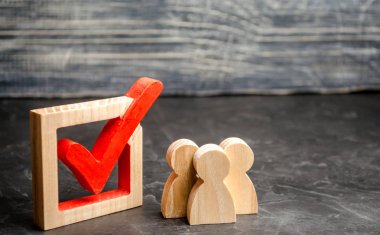 Ahşap insan figürleri birlikte bir onay kutusunun yanındaki bekletin. Seçimler ve sosyal teknolojileri kavramı. Gönüllüler, partiler, adaylar, seçim electorates. İnsan hakları. referandum