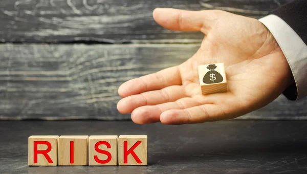 Dollars and the inscription Risk in the hands of a businessman. The concept of financial risk and investing in a business project. Making the right decision. Property insurance. Legal and market risks